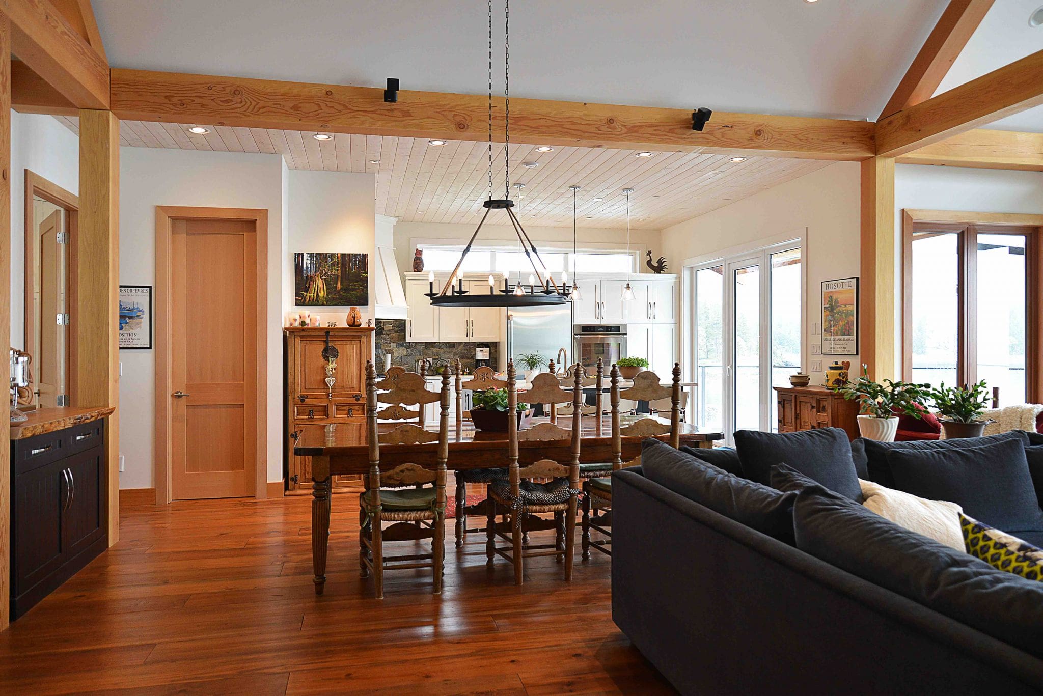 Pender Harbour Timber Frame Home | Streamline Design Ltd Dining table with kitchen behind