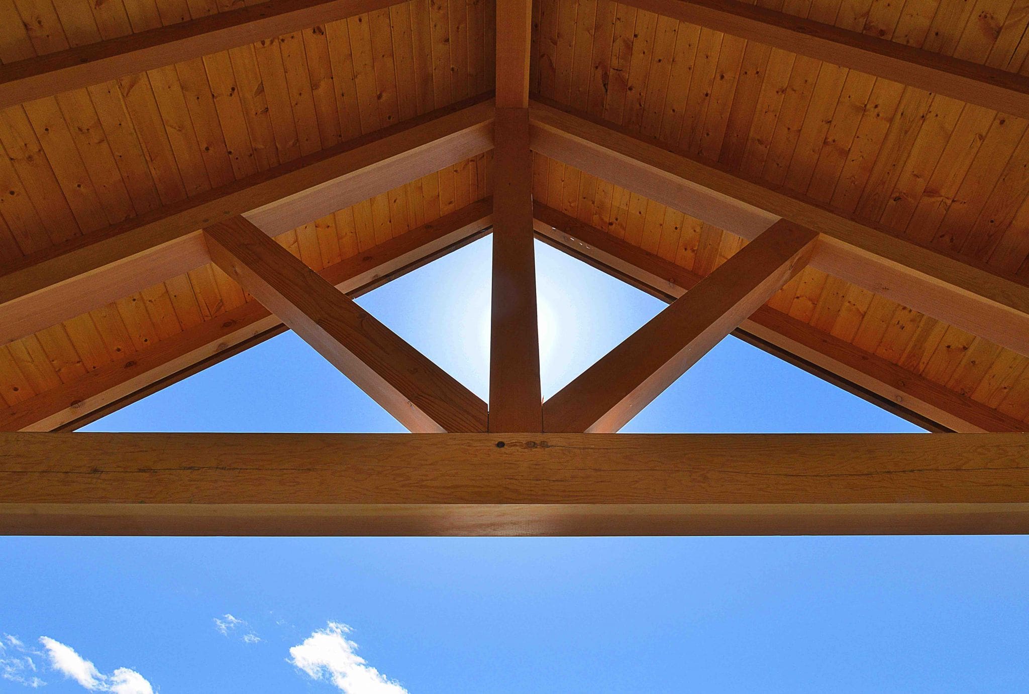 Pender Harbour Timber Frame Home | Streamline Design Ltd External exposed beams with blue sky behind