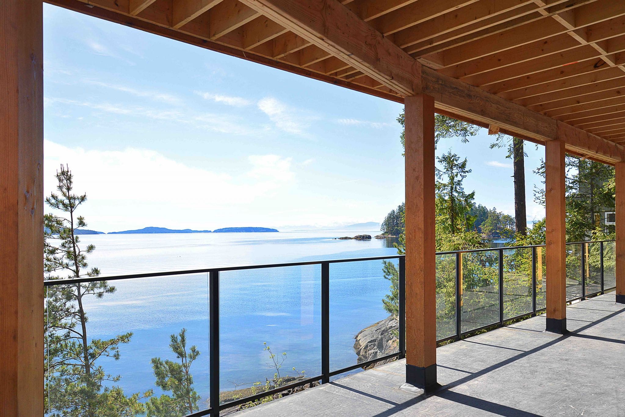 Pender Harbour Timber Frame Home | Streamline Design Ltd The ocean view from the deck of a modern home